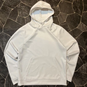 Vit Suede Ciszere Hoodie - Snygg vit hoodie med ficka framtill och huva. Tröjan har långa ärmar och en stilren look utan tryck eller mönster. Perfekt för dig som gillar en clean och enkel stil. Storlek S. Säljs för den inte används tillräckligt 