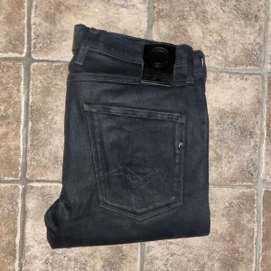 Replay Anbass hyperflex jeans - Svarta Replay Anbass hyperflex jeans med skinny passform och klassisk femficksdesign. Jeansen är tillverkade i stretchigt Hyperflex-material för extra komfort och rörelsefrihet. Midja 42cm, längd 105cm. JAG SKICKAR EJ FLER BILDER NÄR JAG BÄR JEANSEN! för storleksguide hänvisar jag till måtten och för bättre inblick i passformen rekommenderar jag att googla på modellnamnet. Jeansen kan vara uppsydda utan att jag noterat det så kallade måtten noggrant :) s4 