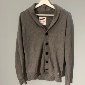 Selected Homme kofta - Säljer en stilren grå kofta från Selected Homme. Det är en äldre tröja från modellen Jailored Denim Vintage. Den sitter som en Liten L och är i mycket bra skick. Den är riktigt fet och passar väldigt bra till vintern. Hör gärna av er för fler frågor !