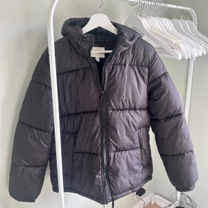 Svart vinter jacka  - Svart pufferjacka från H&M med huva och dragkedja framtill. 