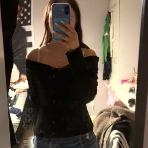 Svart offshoulder långärmad topp - Säljer en svart långärmad topp med offshoulder-design som ger en snygg och trendig look. Toppen är tight och sitter fint över axlarna, perfekt att matcha med jeans eller kjol. Enkel och stilren, passar dig som gillar minimalistisk stil.