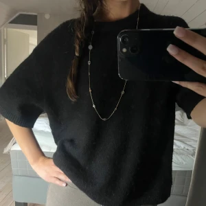 Svart stickad tröja med kort ärm - En svart stickad tröja från Gina Tricot. 