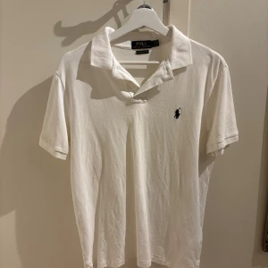 Vit pikétröja från Polo Ralph Lauren - Vit pikétröja från Polo Ralph Lauren i custom slim fit. Mycket bra skick.