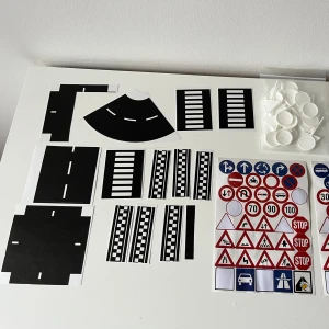 Playbox vägbanekit med vägmarkeringar och trafikskyltar -  Playbox DIY vägbanekit med självhäftande vägmarkeringar, vägskyltar, plastfötter och 10 m vägband. Perfekt för lek med bilar eller tågbanor.