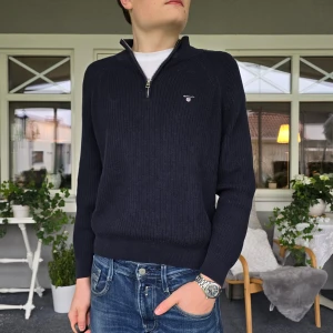 Gant half zip stickad tröja - Snygg blå stickad tröja från Gant. Perfekt nu inför vintern. Är storlek 158-164 cm, men känns lite större. Skulle gissa att de även passar de som är 170-175 cm långa. Jag på bilden är 180 cm lång och tröjan är lite för liten för mig. 😄