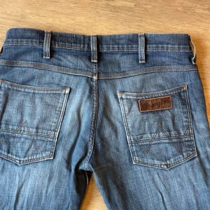 Wrangler blå jeans med raka ben - Det är ett hål på framsidan!