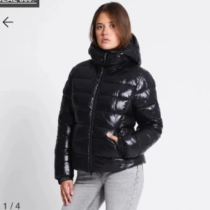 Lager157 jacka💕 - Snygg svart pufferjacka med glansig finish och hög krage. Jackan har en stor huva, dragkedja framtill och quiltad design som ger extra volym. Perfekt för kalla dagar och riktigt street. Långärmad och med fickor på sidorna.