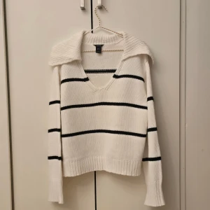 Lindex Randig stickad tröja - 🌷FÖRST TILL KVARN!🌷Svart och vit stickad randig tröja från Lindex. Storlek M, helt ny endast testad. V-urringning med längre krage i bak och breda ärmar. Len och bekväm men tyckte att den var för urringad för min smak men hade då redan tagit bort lappen och tvättat den innan jag insåg det😅. Den är annars superfin och perfekt till det kallare vädret. Fin i sig själv eller med nån skjorta eller polo under. Nyskick utan prislapp.