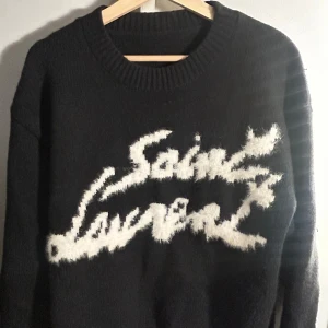 Svart stickad Saint Laurent tröja - Ysl sweater som är tjock och varm för vintern. Jag är en S/M och den passar mig väldigt bra men det är en L så passar också L. Köpte den för att resella men kunde inte hitta något bevis att den är akta vilket ar varför jag saljer den billigt. Ny pris nästan 11000. Den väger 830g så är på den tjockare sidan och har alltid hjälpt mig vara varm. Tveka inte om att meddela mig om något och priset ej hugget i sten.