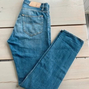 Ljusblå jeans tiger of sweden  29/32 - Säljer ett par ljusblå jeans från tiger of sweden  i klassisk femficksmodell. Jeansen har raka ben och normal passform, tillverkade i bomull med snygga slitningar och detaljerade sömmar. Perfekta för dig som gillar en avslappnad och tidlös look.