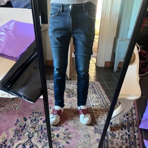 Mörkblå slim jeans från Lee 31/30 - Säljer ett par mörkblå skinny jeans från Replay med klassisk femficksdesign och snygga slitningar framtill. Jeansen har låg midja och är tillverkade i stretchigt jeansmaterial som sitter tajt längs benen. Perfekta för dig som gillar en slimmad look. Modellen är 178cm 70kg midja 38 längd 98cm (8)