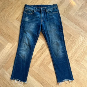 Levi's 511 jeans med råa benslut - Snygga blå Levi's 511 jeans med klassisk femficksdesign och slitna, råa benslut för en cool look. Jeansen har en smal passform och är tillverkade i mjukt denimtyg. Perfekta för dig som gillar en avslappnad men trendig stil.