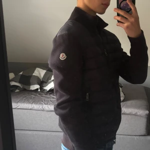 Moncler Cardigan Intressekoll - Intressekoll på Moncler Cardigan. Storlek S, men passar som mellan XS och S. Som det syns på 3:e bilden så är det en liten defekt, samt att jackan på vissa ställen har en brun nyans i vissa ljus, syns också på bild 3. Hör av er vid frågor.