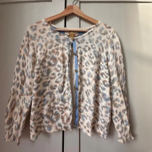 Leopardmönstrad kofta från H&M, M men känns som Xs - Säljer en superfin kofta från H&M i beige med blått och brunt leopardmönster. Snygga blommiga knappar och ljusblå kant längs knäppningen. Långärmad och ribbade muddar. Perfekt för dig som vill sticka ut lite extra på ett gulligt sätt. Storleken är M men är liten i storleken så skulle säga att den är som en S/Xs. Använd fåtal gånger, Ny pris är 450 kr men säljer för ca 200 kr pris kan diskuteras🩷