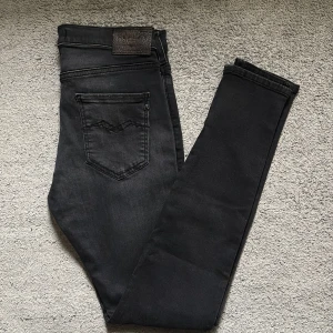 Svarta Replay Stella jeans med dragkedjor - Snygga svarta jeans från Replay, modell Stella, i stretchigt material. Smal passform med dragkedjor vid bensluten och klassiska bakfickor. Perfekta för dig som gillar en stilren look med edge.