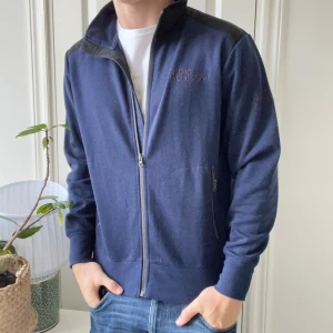 Oscar Jacobsson full zip  - Oscar Jacobsson full zip i storlek M. Har logga på ärmen och på bröstet. Sitter väldigt najs! Modellen är 180,75 kg ✌️