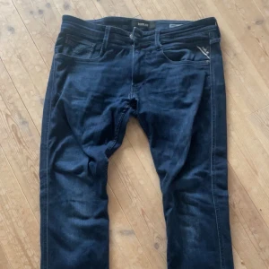 Mörkblå Replay jeansbyxor - Säljer ett par mörkblå jeans från Replay med klassisk femficksdesign och dragkedja. Jeansen har en snygg tvätt och raka ben, perfekta för en avslappnad och stilren look.