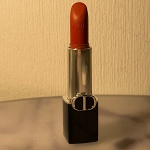 Dior Rouge Dior 720 Icône Satin Läppstift - ✨ Dior läppstift – 720 Icône (satin) ✨ Lyxigt Dior-läppstift i nyansen 720 Icône – en varm rödbrun statement-färg med satin-finish. Klassisk svart hylsa med silverdetaljer. Testat endast ett fåtal gånger, köpt för 448kr. 