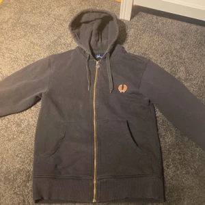 Zip hoodie Fred Perry - Säljer en riktigt fräsch fred Perry zip hoodie med några små defekter som syns på bild 2 och 3. Dessa hål är för det mesta gömda bakom fickorna och går absolut att fixa med lite nål och tråd om man vill det, men därav det låga priset. Storleken är S men skulle säga att den passar som Xs. Hör av dig vid minsta lill fråga och priset kan eventuellt diskuteras💪