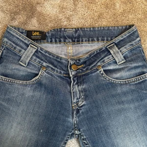 Blå bootcut jeans från Lee - Snygga blå jeans från Lee med klassisk bootcut-passform och låg midja. Modellen heter Leola. 🤍 Säljer då de är lite för stora i midjan och för korta för mig🩷 Jag kan tyvärr inte hitta nypriset, men motsvarande modeller ligger runt 1000kr.❣️