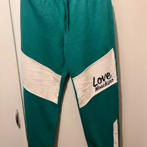 Love Moschino byxor  - Love Moschino byxor i strl UK 12 (motsvarar strl 40). Helt nya, aldrig använda.  Se mina andra annonser då jag även säljer tröjan som hör till.  Material: bomull  Nypris: 2 228 kr 
