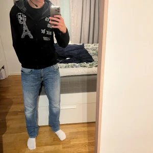 Blå Replay jeans Rocco comfort fit - Säljer ett par blå Replay jeans, modell Rocco comfort fit. Jeansen har klassisk femficksdesign, raka ben och snygga slitningar framtill. De är tillverkade i jeansmaterial och har en bekväm passform som funkar till många olika stilar.