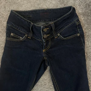 Low waist vintage jeans - Jätte fina och jättelågmidjade vintage jeans från bikbok. Dom är straight men kan se bootcut ut. Färgen har gått bort lite smått på baksidan av ena benet, men det märks knappast eftersom det är ”skrynkligt” där när man har på sig dom. 🥰 utöver det finns det inte nåt o klaga på😂säljer endast för att jag behöver pengar😋pris kan diskuteras!!!!