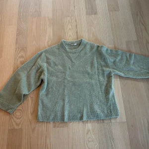 Grön stickad tröja från Gina Tricot - Mysig ljusgrön stickad tröja från Gina Tricot med rund halsringning och ribbade muddar vid ärmslut, knappt använd