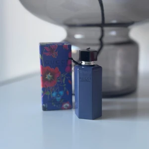 Gucci Flora parfym med ask - Gucci Flora parfym i snygg, modern flaska med tillhörande färgglad ask. Perfekt för dig som vill sticka ut med en ikonisk accessoar från ett av världens mest kända modehus.