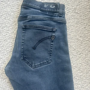 Dondup jeans - Snygga jeans från Dondup i en mörkblå/gråaktig tvätt med diskreta slitningar. Jeansen kostar 3500kr nypris. I princip helt nya, modell ritchie