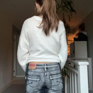 Grå  jeans från A+ Jeans - Säljer ett par grå jeans från A+ Jeans med cool slitning och detaljer på framsidan av benen. Jeansen har låg midja och raka bakfickor med dekorativa sömmar. Materialet är klassisk denim och passformen är normal. Perfekta för dig som gillar en edgy stil.