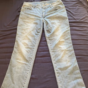 Ljusblå bootcut jeans från Flash - Snygga ljusblå jeans från Flash med klassisk baggy och bootcut-ben. Jeansen har normal passform och är tillverkade i mjukt denimtyg. Perfekta för dig som gillar en avslappnad och tidlös look. Nedsydda till low waist