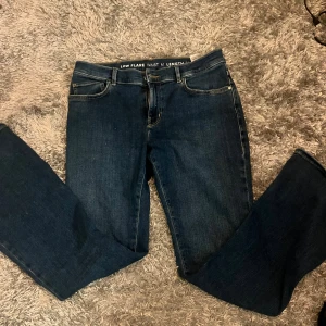 Mörkblå low flare jeans midja M - Snygga mörkblå jeans med låg midja och flare. Jeansen har en stilren look och passar perfekt till sneakers eller boots. Knappt använda, säljer då de inte är i min storlek!