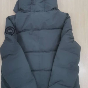 Mörkgrå pufferjacka från Canada Goose pris kan diskuteras - Säljer en mörkgrå pufferjacka från Canada Goose i storlek M. Jackan har huva, diskret logga på ärmen och breda quiltade paneler. Materialet är slitstarkt och jackan har dragkedja framtill. Perfekt för kalla dagar och riktigt snygg streetstil .  Pris kan diskuteras