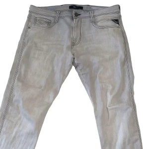 Replay Anbass ljusgrå jeans - Replay herrjeans – grå slim fit snygg tvätt stl waist(34) length (32)  Säljer snygga Replay jeans i grå tvätt i klassisk femficksmodell med knäppning och dragkedja fram. Modellen är slim fit. Jeansen är i fint skick utan hål eller fläckar. Perfekta vardagsjeans som passar till det mesta. Märke Replay färg grå modell slim fit stl'fint skick.  Pris 400 kr (kan diskuteras) Kan träffas