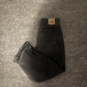 Svarta jeans från Sweet Skateboarding - Svarta jeans från Sweet Skateboarding Company med klassisk femficksdesign och snyggt läderpatch bak. Jeansen har raka ben och baggy design, tillverkade i robust bomullsdenim. Perfekta för en avslappnad streetstil.