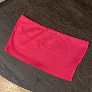 Rosa bandeau tubtopp från Bik Bok - Säljer en snygg rosa bandeau tubtopp från Bik Bok i storlek S. Toppen är ärmlös och har en enkel, stilren design i stretchigt material som sitter tight. 