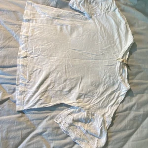 Vit blus - Supersöt vit blus från H&M Divided med armar med broderad spets. Skriv om du har frågor eller vill ha fler bilder.