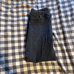 Svarta jeans från Grunt - Snygga svarta jeans från Grunt i ekologisk bomull. Klassisk femficksmodell med knapp och dragkedja framtill. Jeansen har en rak passform och är perfekta för dig som gillar en stilren look. Storlek är w 26 i barnstorlek