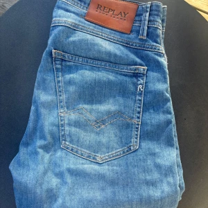 Replay ljusblå slim fit jeans - Säljer ett par ljusblå jeans från Replay i modellen Willbi X-Lite. Jeansen har klassisk femficksdesign, snygga kontrastsömmar och läderpatch med Replay-logga bak. Regular slim fit med bekväm passform, perfekta till din vardagsstil.