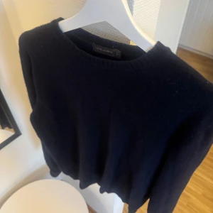   Oscar Jacobson tröja - En klassisk mörkblå rundhalsad tröja från Oscar Jacobson i mjuk ull. Perfekt för lager-på-lager och enkel att matcha med både jeans och chinos. Tröjan har en stilren design med ribbade muddar vid ärmslut och nederkant.