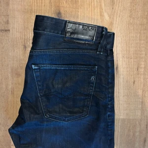 Replay jeans - Snygga mörkblå jeans från Replay, modell Jennon, tillverkade i Italien. Klassisk femficksdesign med raka ben och diskreta detaljer. Jeansen har en stilren look och är gjorda i slitstarkt denimtyg med Replay-logga på bakfickan och vid linningen.