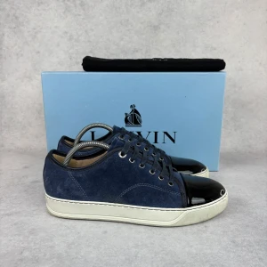LANVIN DBB1 CAP TOE SNEAKER -  – Condition: 9/10  - Size: 40/UK6  – What is included: Box & dustbag (injured box)  – Retail price: 5000 + SEK  Please note that Lanvins fit big and our recommendation is to go one size down