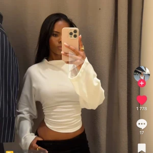 Vit långärmad topp från Gina Tricot - Aldrig använd Säljer en vit långärmad topp från Gina Tricot med croppad passform och snygg knytning i ryggen. Toppen har en hög hals och är tillverkad i mjuk bomullsmix. Perfekt för dig som gillar stilrena och trendiga plagg.