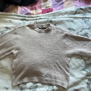 Beige stickad tröja från 157 XS - Mysig beige stickad tröja från 157 i storlek XS. Tröjan har en rund halsringning, lång ärm och en lätt croppad passform. Perfekt för lager-på-lager och chill dagar. Enkel och stilren design som funkar till det mesta.