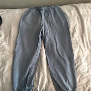 Grå-blå mjukisbyxor från Weekday M - Grå-blå mjukisbyxor från Weekday i storlek M. Byxorna har resår i midjan och vid bensluten samt en bakficka. Tillverkade i mjukt bomullsmaterial för maximal komfort. Perfekta för chill dagar eller när du vill vara extra bekväm.