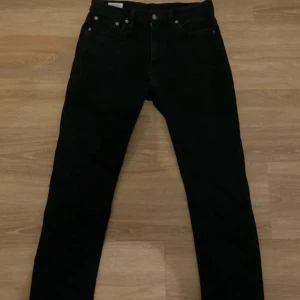Svarta Levi's 511 jeans w30 l32 - Svarta Levi's 511 jeans med klassisk femficksdesign och smal passform. Jeansen har en rak siluett, normal midja och är tillverkade i ett mjukt jeansmaterial. Perfekta för dig som gillar en clean och stilren look.