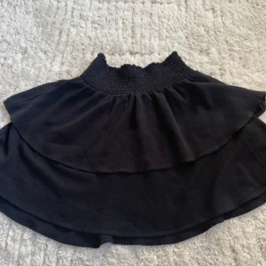 Svart volangkjol med smock - Minikjol med volanger. Använd många gånger och lite nopprig.