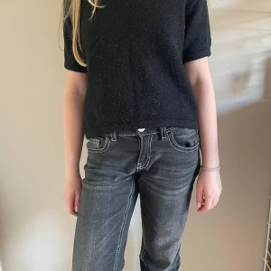 Svart stickad tröja från Gina Tricot - Svart stickad kortärmad tröja från Gina Tricot. Storlek 146/152. 