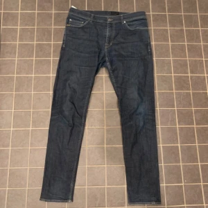 Mörkblå jeans Evolve 36/34 - Snygga mörkblå jeans från Evolve i klassisk femficksmodell. Jeansen har raka ben och normal passform, tillverkade i slitstarkt denimtyg. Perfekta för dig som gillar stilrena och enkla jeans med diskreta detaljer.